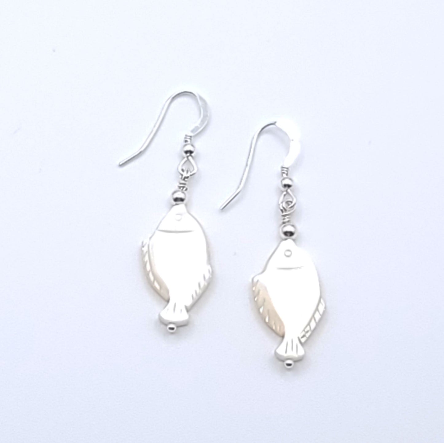Lucky Fish Earrings featuring genuine mother-of-pearl fish with sterling silver ear wires.