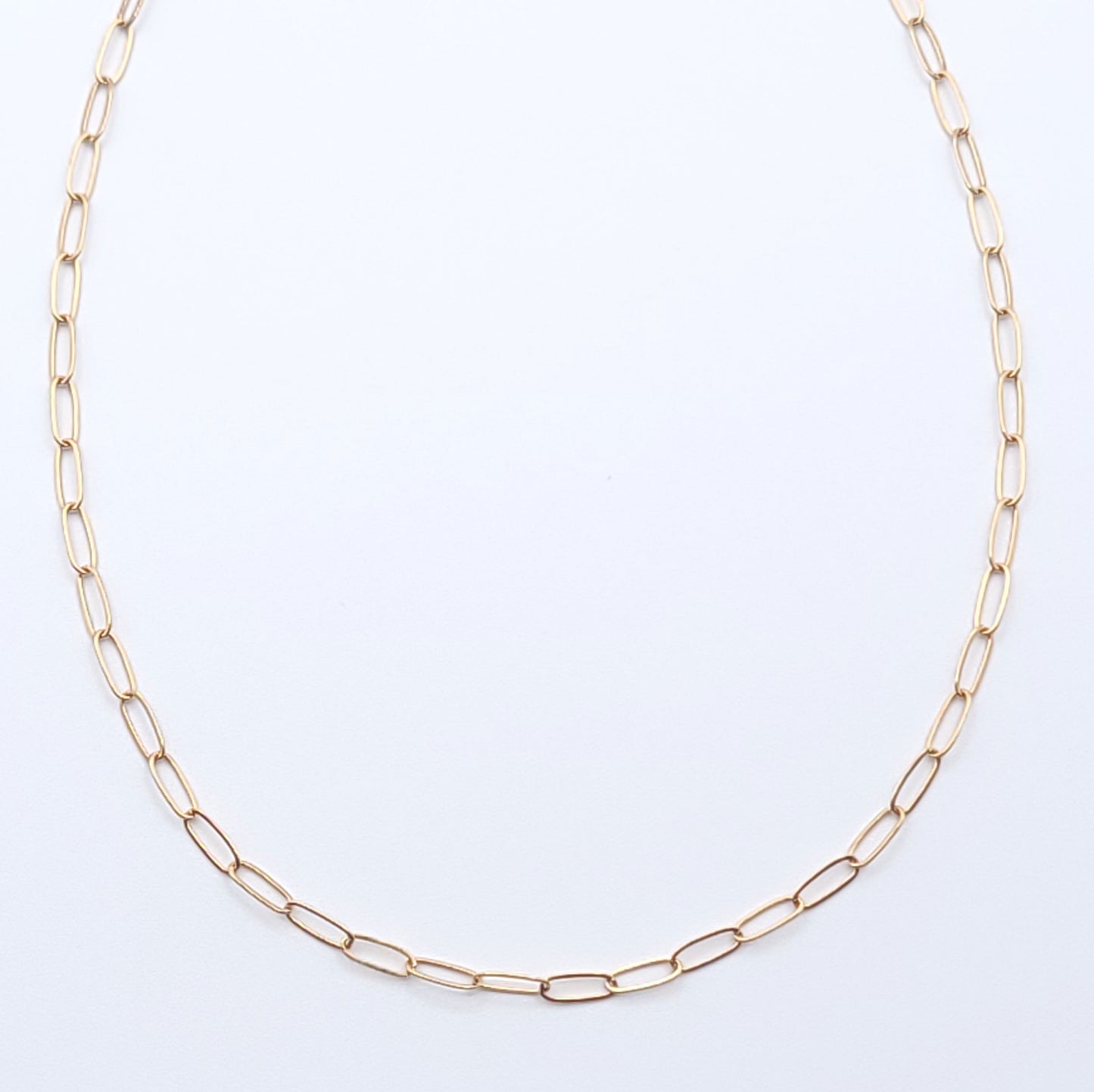 Minimal gold-filled essential chain necklace on a soft light gray background