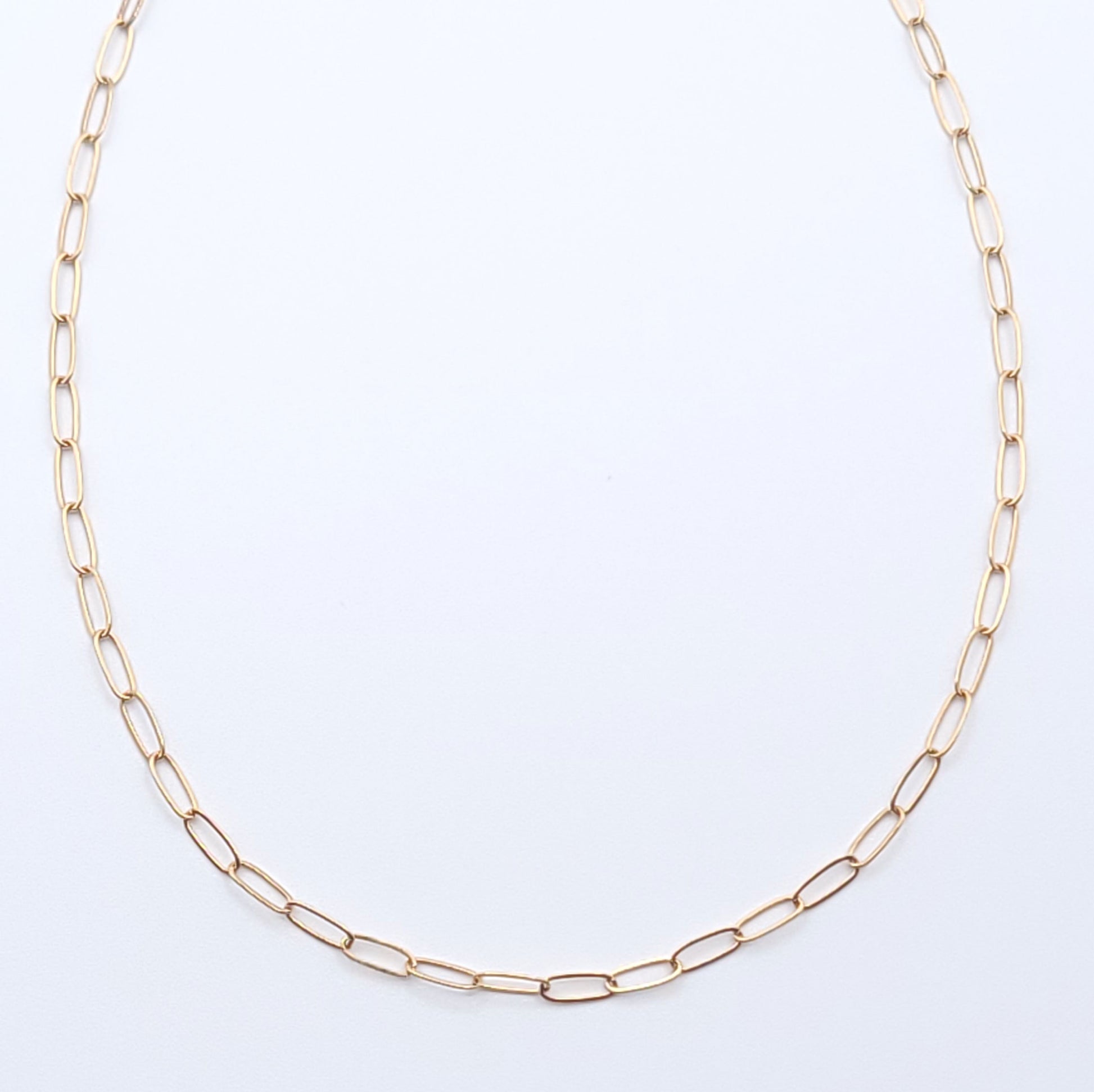 Minimal gold-filled essential chain necklace on a soft light gray background