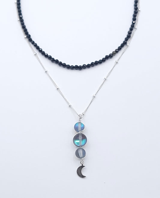 Layered sterling silver midnight necklace stack featuring the Moon Phases Silver Aura necklace and Boundless Protection choker on a soft light gray background