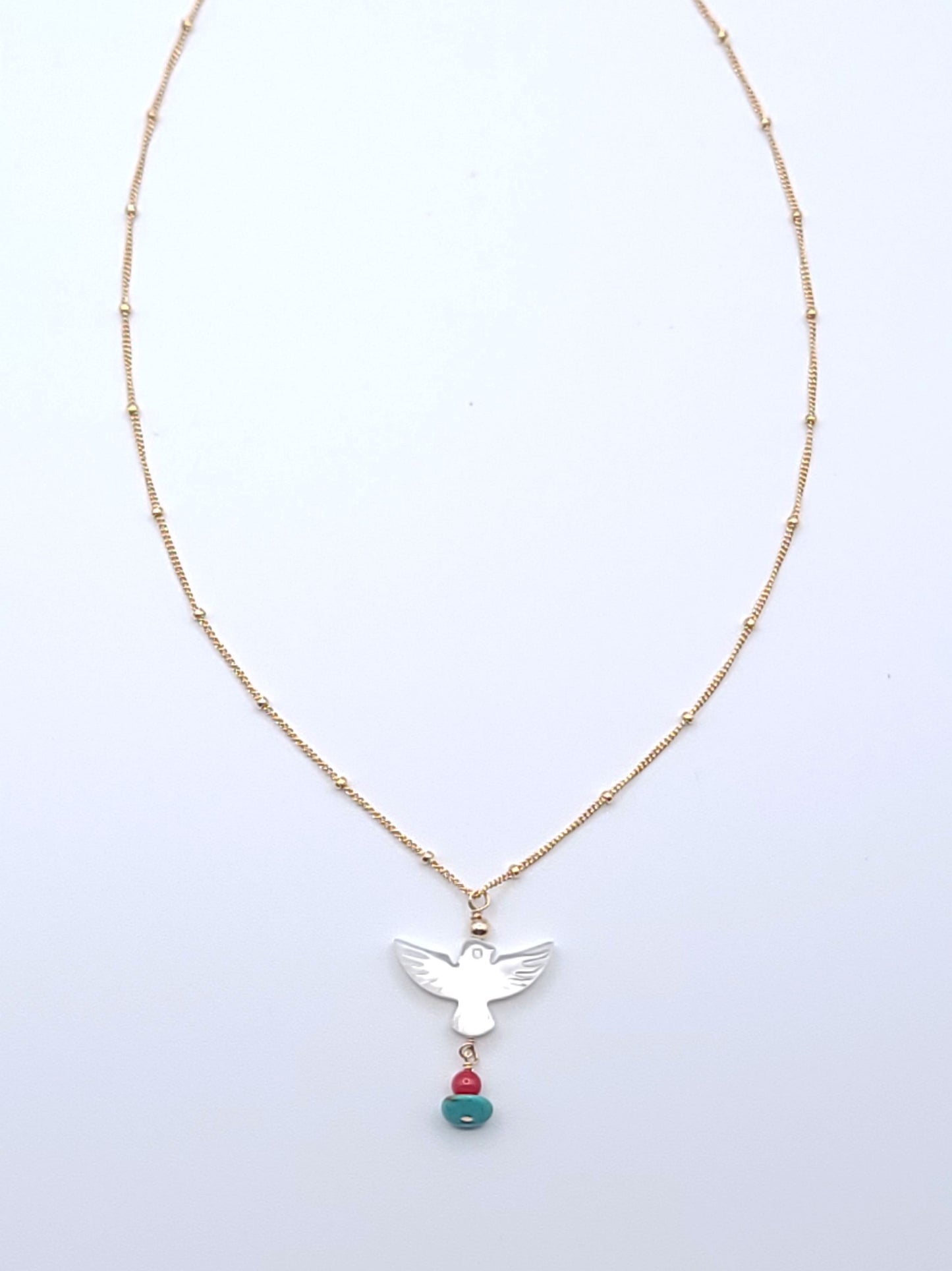 Wings of Hope Necklace featuring a mother-of-pearl bird pendant accented with turquoise and coral on an 16-inch gold-filled satellite chain.