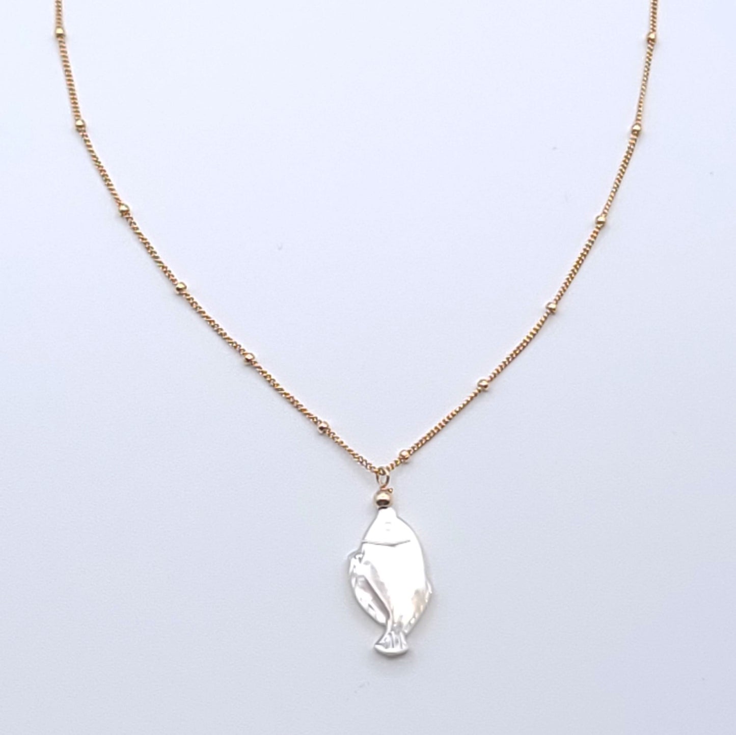 Lucky Fish Necklace featuring a natural mother-of-pearl fish pendant on an 16-inch gold-filled satellite chain.