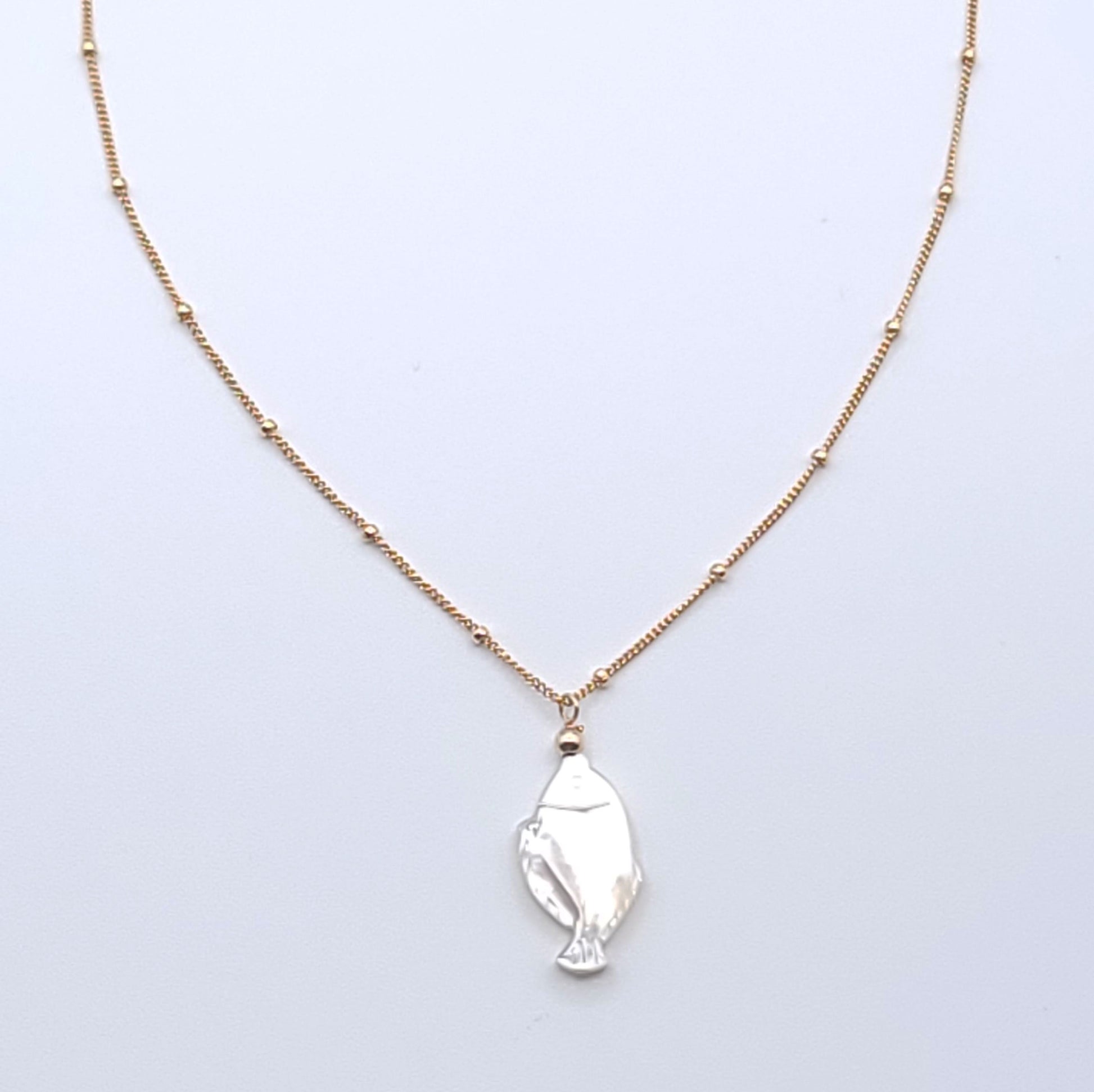 Lucky Fish Necklace featuring a natural mother-of-pearl fish pendant on an 16-inch gold-filled satellite chain.