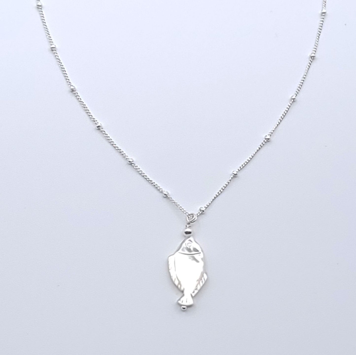 Lucky Fish Necklace featuring a natural mother-of-pearl fish pendant on an 16-inch sterling silver satellite chain.
